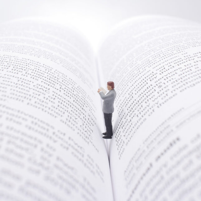 figurine standing int he middle of a book. -- first opinion coverage from STAT