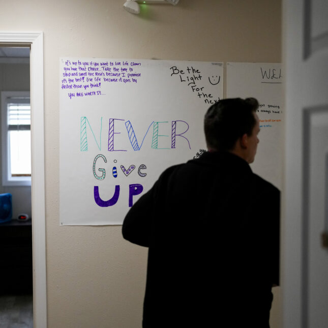 A person walks past a sign in an opioid treatment facility. -- first opinion coverage from STAT