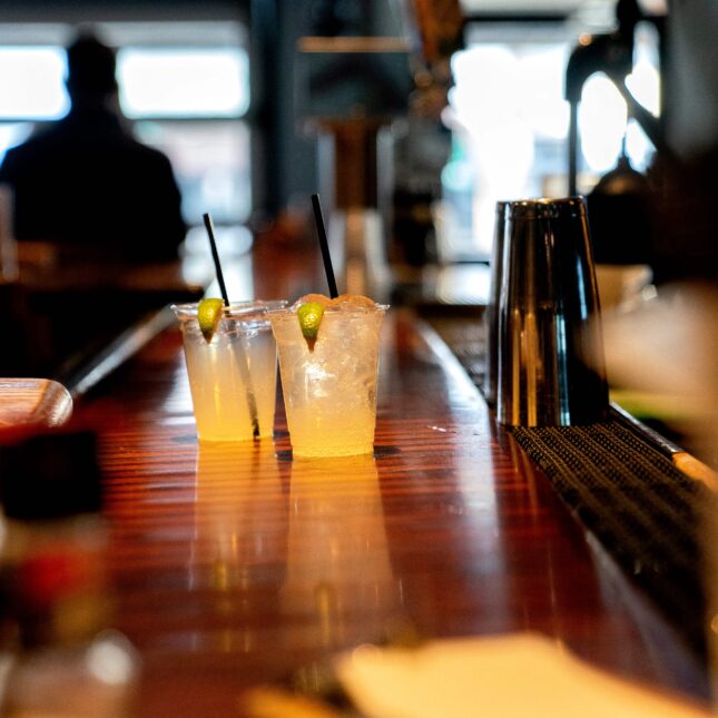 Photograph of two alcoholic cocktails on a bar