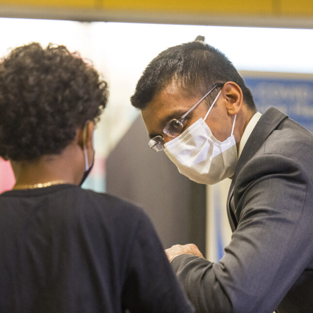 A young patient elbow bumps Health Commissioner Dr. Dave A. Chokshi as he prepares to receive the coronavirus (COVID-19) vaccine. -- health coverage from STAT