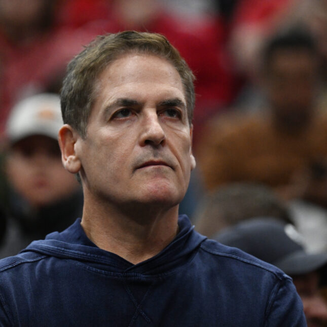 American businessman Mark Cuban, a white person with short hair wearing dark blue shirt, looks up during an NBA game — first opinion coverage from STAT