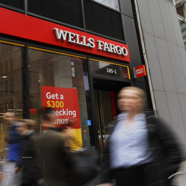 People walk past a Wells Fargo bank -- health business coverage from STAT