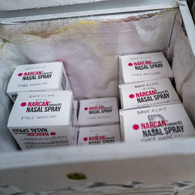 An open box containing several boxes of Narcan stands on an avenue — first opinion coverage from STAT