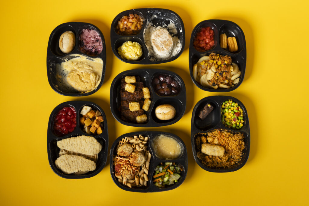 An assortment of meals from Homestyle Direct photographed on a bright yellow backdrop